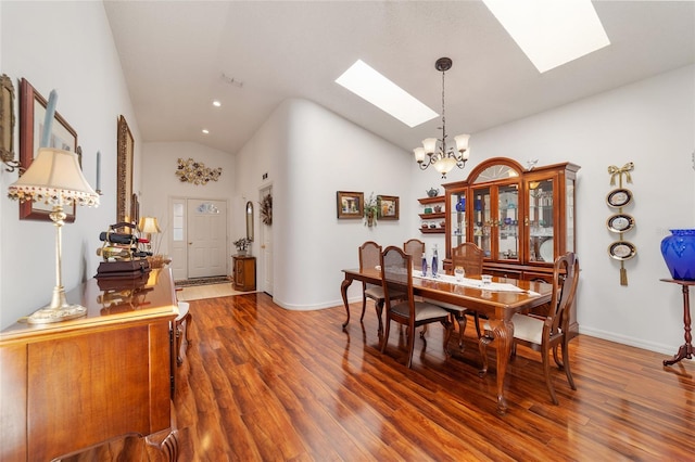 dining area featuring a chandelier, dark wood-type flooring, high vaulted ceiling, and a skylight