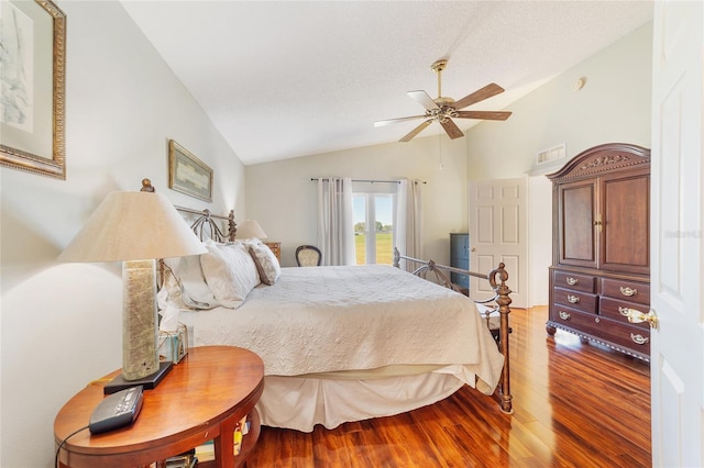 bedroom with ceiling fan, wood-type flooring, lofted ceiling, and a textured ceiling