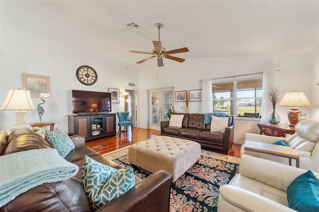 living room with french doors, hardwood / wood-style flooring, ceiling fan, and lofted ceiling