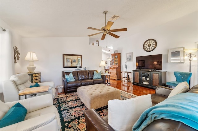 living room with ceiling fan, vaulted ceiling, and hardwood / wood-style flooring