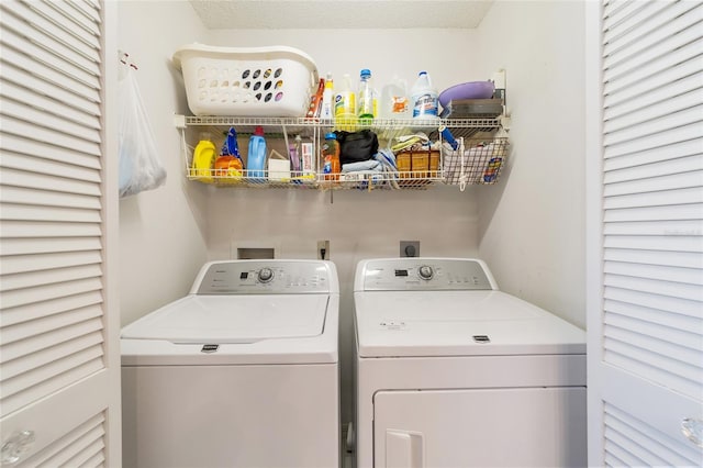 clothes washing area with a textured ceiling and independent washer and dryer