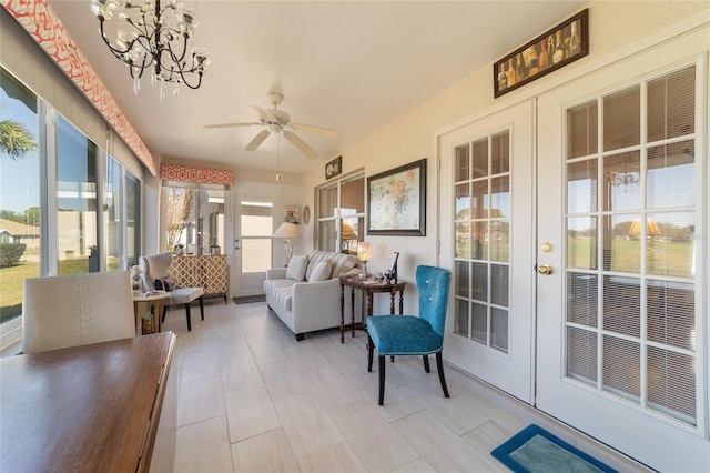 sunroom / solarium with ceiling fan with notable chandelier