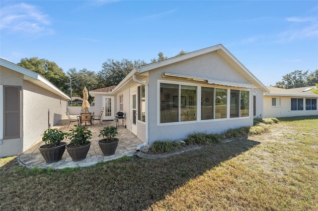 view of side of property with a lawn and a patio