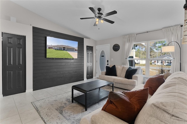 tiled living room with ceiling fan, wood walls, and lofted ceiling