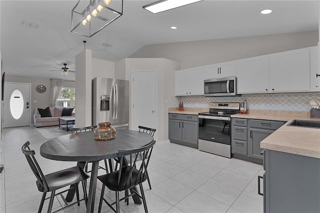 kitchen featuring appliances with stainless steel finishes, lofted ceiling, ceiling fan, and gray cabinetry