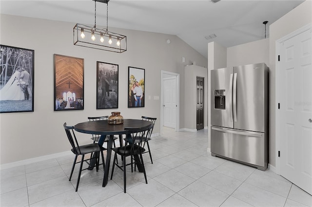 tiled dining area featuring vaulted ceiling