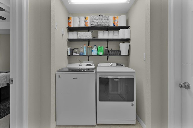 laundry room with washer and clothes dryer and light tile patterned floors