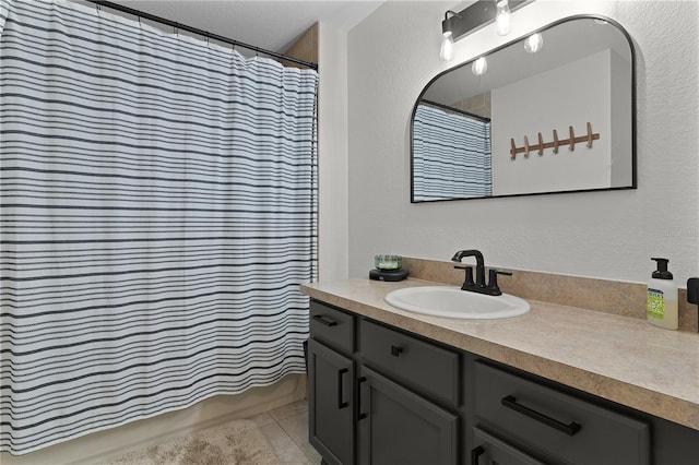 bathroom featuring tile patterned flooring, vanity, a textured ceiling, and a shower with shower curtain