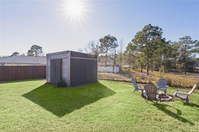 view of yard with a shed and an outdoor fire pit