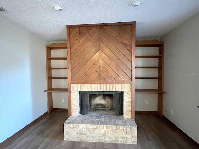 unfurnished living room featuring dark wood-type flooring, a textured ceiling, and a fireplace