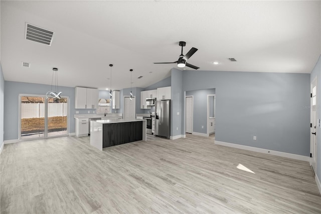 kitchen featuring white cabinetry, hanging light fixtures, appliances with stainless steel finishes, a kitchen island, and light wood-type flooring