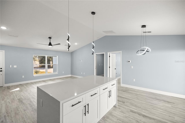 kitchen featuring white cabinets, hanging light fixtures, vaulted ceiling, ceiling fan, and light wood-type flooring