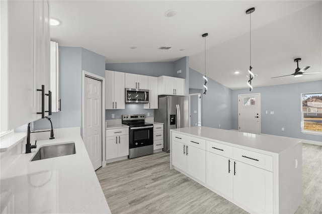 kitchen with white cabinets, pendant lighting, sink, and stainless steel appliances