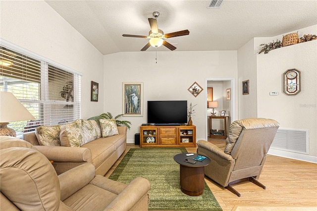 living room featuring ceiling fan, light hardwood / wood-style floors, and vaulted ceiling