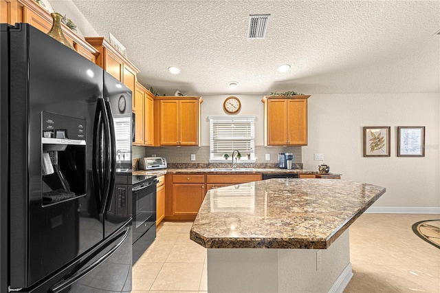 kitchen with sink, a kitchen island, black appliances, and light tile patterned floors