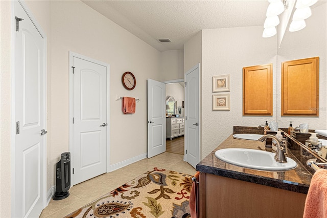 bathroom featuring tile patterned flooring, a textured ceiling, and vanity