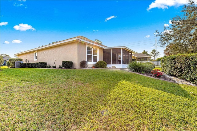 rear view of property with a sunroom and a lawn