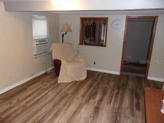 living area with dark hardwood / wood-style flooring and cooling unit