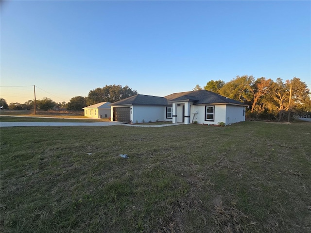 ranch-style home with a yard and a garage