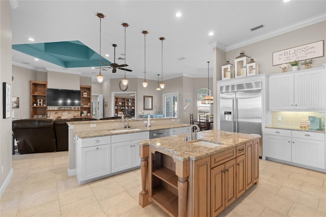 kitchen featuring sink, white cabinets, pendant lighting, and a spacious island