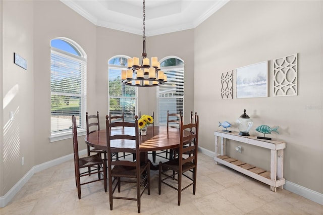 dining room featuring a wealth of natural light, a raised ceiling, and a chandelier