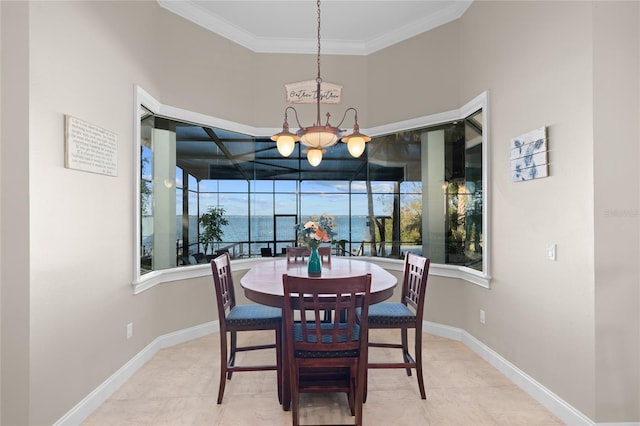 tiled dining space with a water view and crown molding