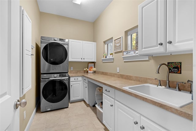 washroom featuring sink, stacked washing maching and dryer, light tile patterned floors, and cabinets