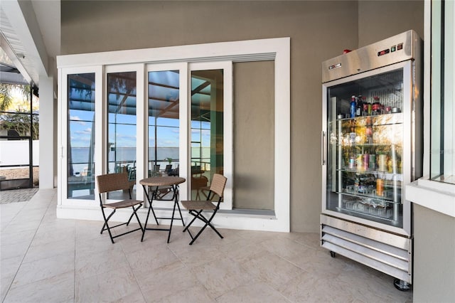 view of patio featuring beverage cooler and a water view