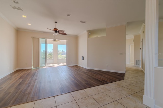 spare room featuring light tile patterned floors, ceiling fan, and crown molding