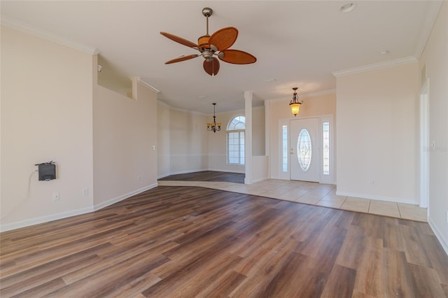 entrance foyer featuring crown molding, wood-type flooring, and ceiling fan with notable chandelier