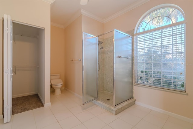 bathroom featuring tile patterned flooring, a tile shower, toilet, and ornamental molding