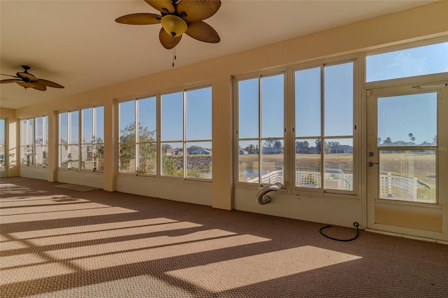 unfurnished sunroom with ceiling fan and a wealth of natural light