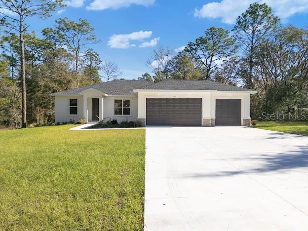 view of front of home with a front yard and a garage