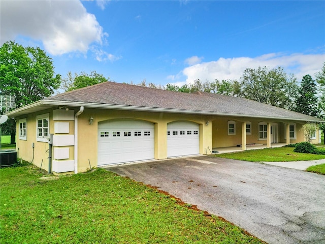 view of front of property with a garage, a front lawn, and central air condition unit