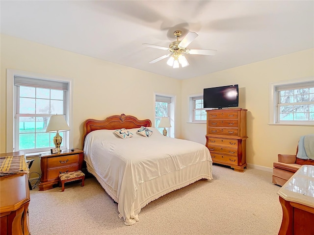 carpeted bedroom with ceiling fan and multiple windows