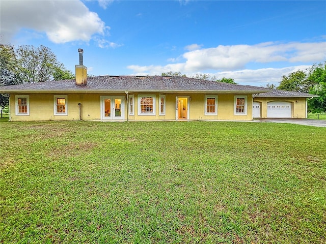 ranch-style home with french doors, a front yard, and a garage