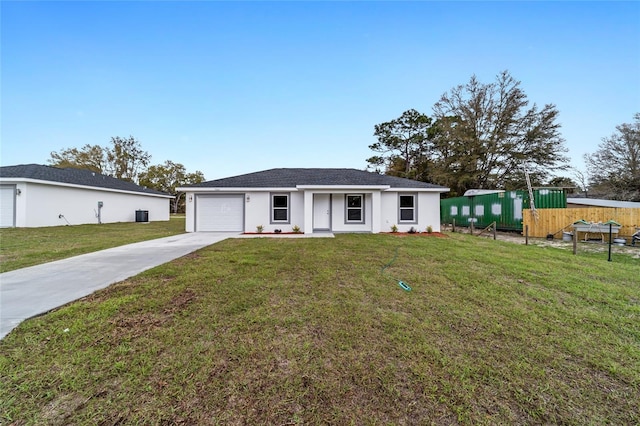 view of front facade with an attached garage, fence, driveway, stucco siding, and a front lawn