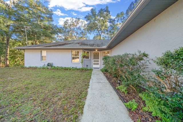 doorway to property featuring a lawn