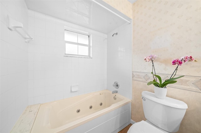 bathroom featuring tiled shower / bath combo and toilet