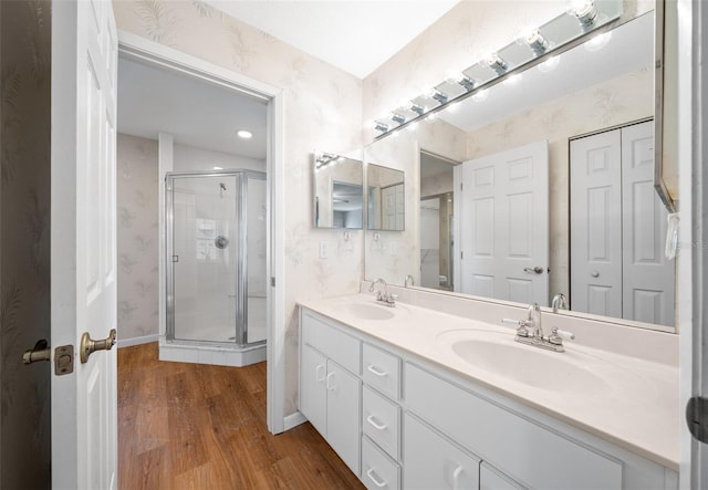 bathroom with a shower with door, vanity, and hardwood / wood-style floors