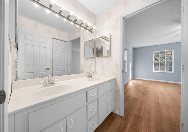 bathroom with vanity, wood-type flooring, and a textured ceiling