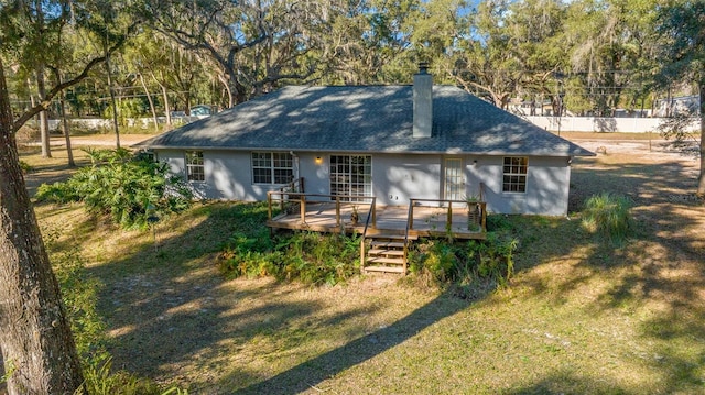 rear view of property featuring a lawn and a wooden deck