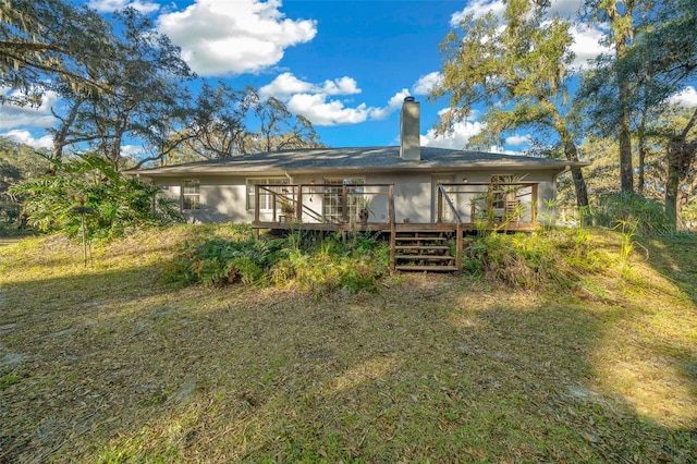 back of property with a lawn and a wooden deck