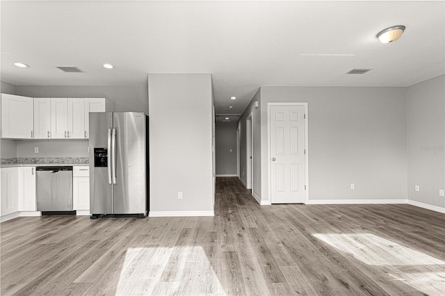 kitchen with white cabinets, appliances with stainless steel finishes, and light wood-type flooring