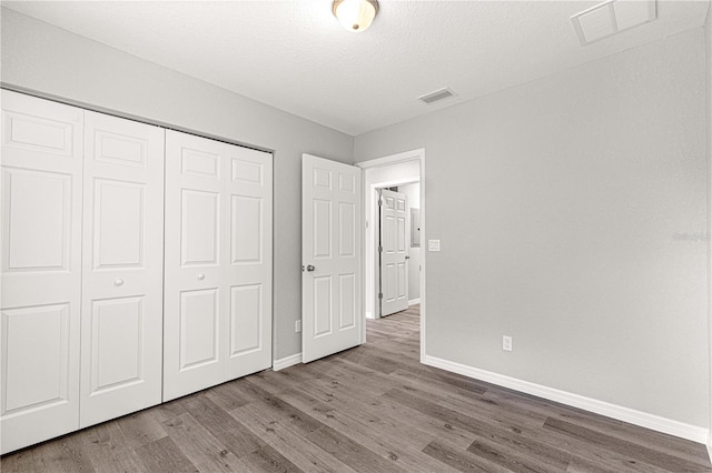 unfurnished bedroom with hardwood / wood-style flooring and a closet