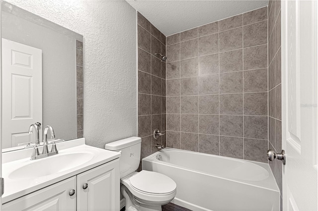 full bathroom featuring vanity, tiled shower / bath combo, a textured ceiling, and toilet