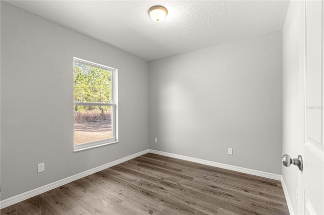 unfurnished room with a textured ceiling and dark hardwood / wood-style flooring