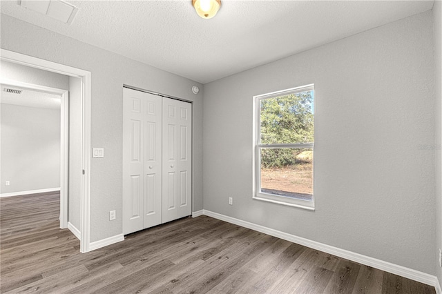 unfurnished bedroom with light hardwood / wood-style flooring and a closet