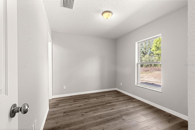 spare room with dark hardwood / wood-style flooring and a textured ceiling