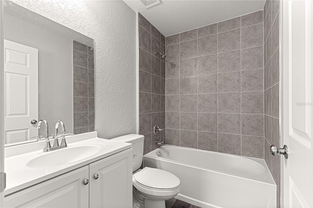 full bathroom with shower / bathtub combination, vanity, a textured ceiling, and toilet